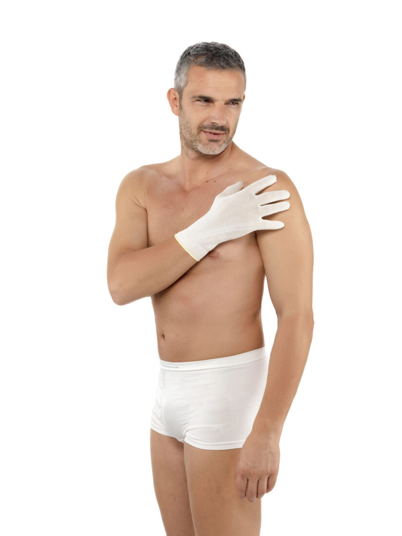 En man klädd i boxershorts och en hand placerad på axeln med en DermaSilk handske