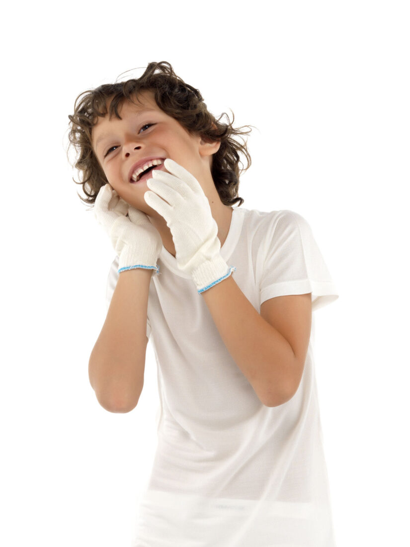 Glad kille med brunt hårklädd i DermaSilk handskar och kortärmad t-shirt