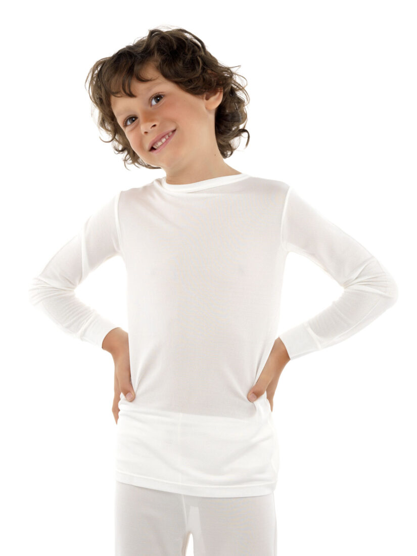 En brunhårig kille som håller händerna på höfterna och är klädd i DermaSilk undertröja för barn