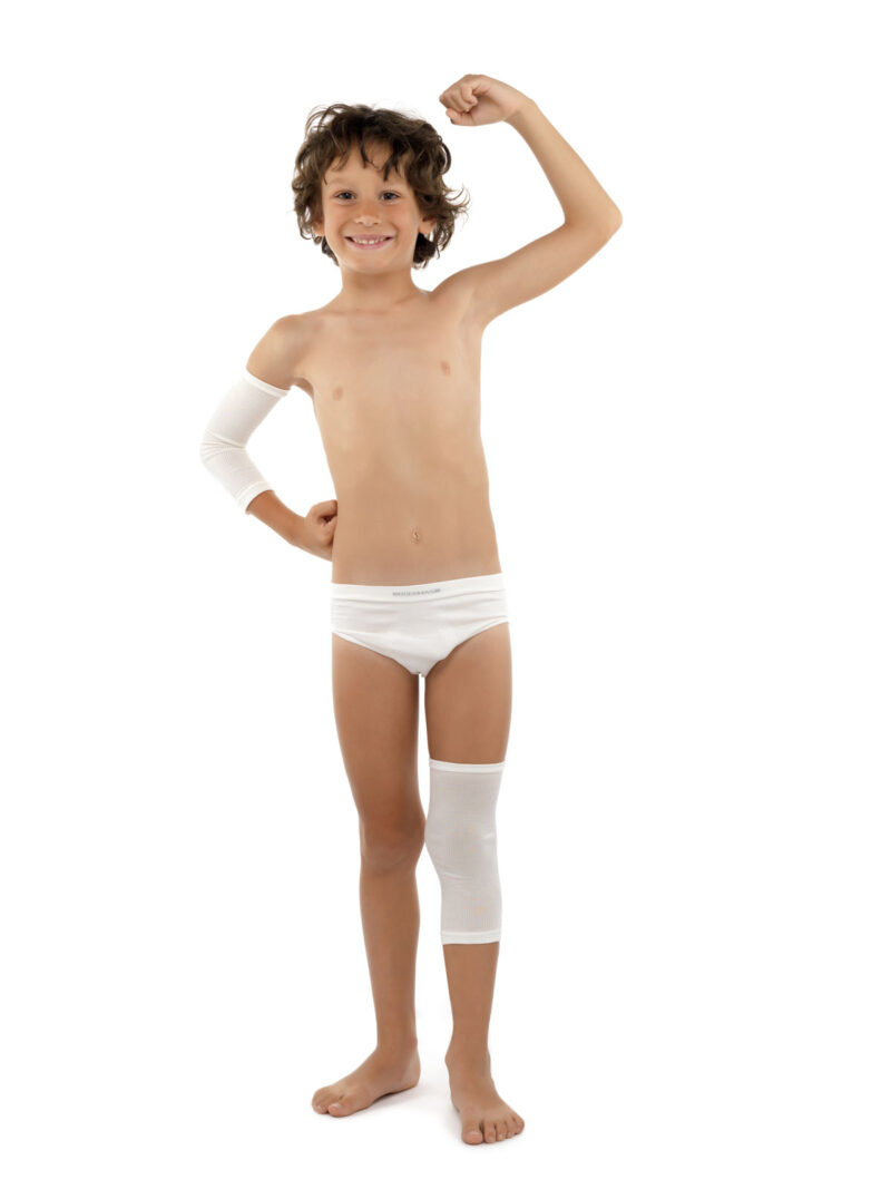 Glad brunhårig kille med power posé klädd i DermaSilk tubformat bandgage på armbåge och knä.